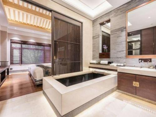 a bathroom with a large tub and a bedroom at Xian Huaqingyutang Hotel in Xi'an