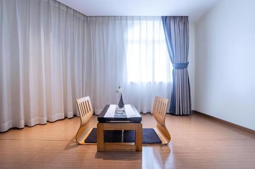 a dining room with a table and two chairs at Zhongshan Louis Hotel in Zhongshan