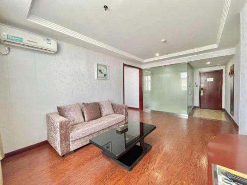 a living room with a couch and a glass table at GreenTree Inn Yinchuan Pedestrian Street East Liqun Street Express Hotel in Yinchuan