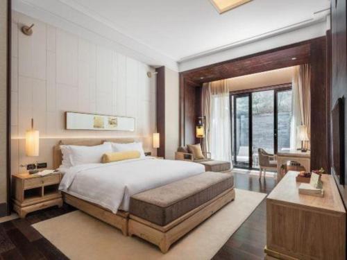a bedroom with a large bed and a living room at Xian Huaqingyutang Hotel in Xi'an