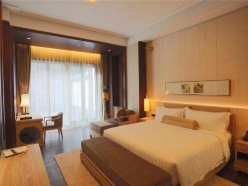 a hotel room with a bed and a desk at Xian Huaqingyutang Hotel in Xi'an