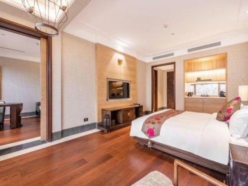 a bedroom with a large bed and a living room at Xian Huaqingyutang Hotel in Xi'an