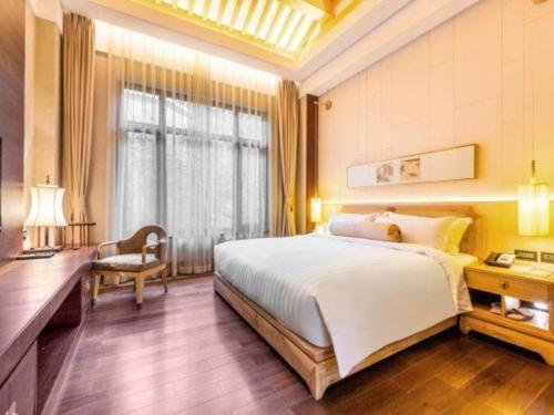 a bedroom with a bed and a desk and a window at Xian Huaqingyutang Hotel in Xi'an
