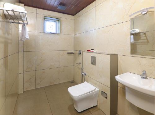 a bathroom with a toilet and a sink and a shower at Evaara Resorts in Anachal