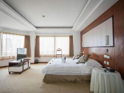 Un dormitorio grande con una cama grande y una mesa. en Expo Garden Hotel, en Kunming