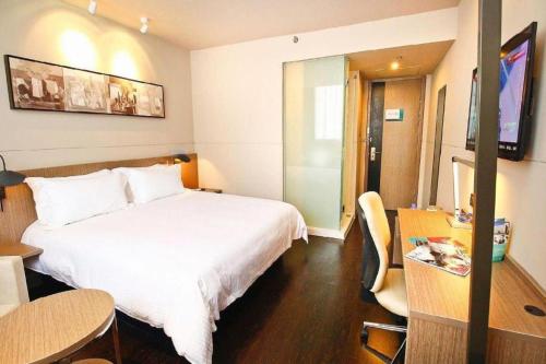 a hotel room with a large white bed and a table at Jinjiang Inn Xi'an Zhonglou North Street Metro Station in Xi'an