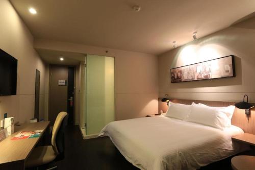 a hotel room with a bed and a table and a mirror at Jinjiang Inn Xi'an Zhonglou North Street Metro Station in Xi'an