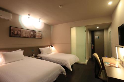 a hotel room with two beds and a mirror at Jinjiang Inn Xi'an Zhonglou North Street Metro Station in Xi'an