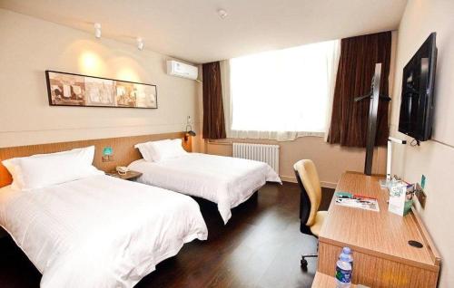 a hotel room with two beds and a desk at Jinjiang Inn Xi'an Zhonglou North Street Metro Station in Xi'an