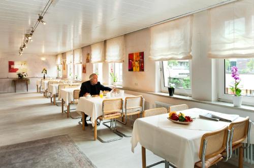 a man sitting at a table in a restaurant at STADT-Hotel Lörrach GbR in Lörrach