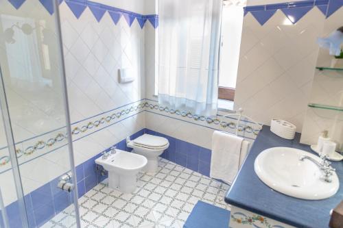 a blue and white bathroom with a toilet and a sink at Nel cuore del centro storico di Maratea in Maratea