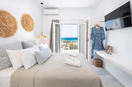 a bedroom with a bed with a view of the ocean at Akrogiali Rooms in Agia Anna Naxos
