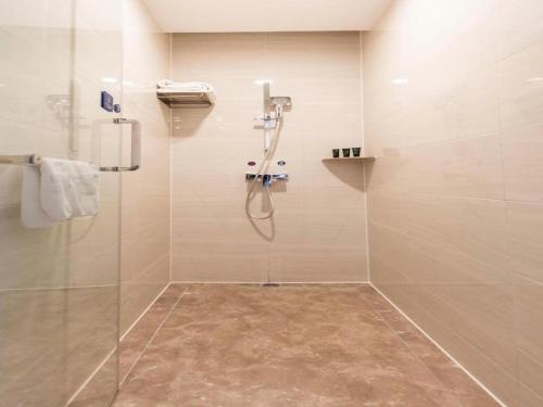 a bathroom with a shower with a glass door at Kyriad Marvelous Hotel·Xi'an North High-speed Railway Station in Xi'an