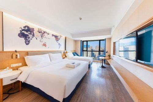 a hotel room with a large bed and a large window at Kyriad Marvelous Hotel·Xi'an North High-speed Railway Station in Xi'an