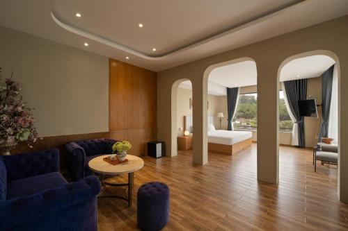 a living room with a bed and a couch and a table at Gold View Boutique Hotel Đà Lạt in Da Lat