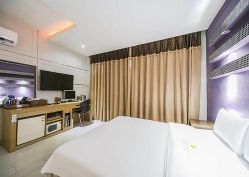 a hotel room with a bed and a desk at Nostalgia Hotel in Paju