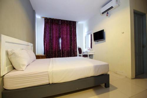 une chambre avec un grand lit avec une fenêtre dans l'établissement Wijaya Imperial Hotel, à Demangan