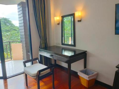 a desk with a chair and a mirror and a window at khaoyai lumtakong hotel in Mu Si