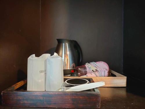 a wooden tray with toilet paper and a cup on a table at khaoyai lumtakong hotel in Mu Si