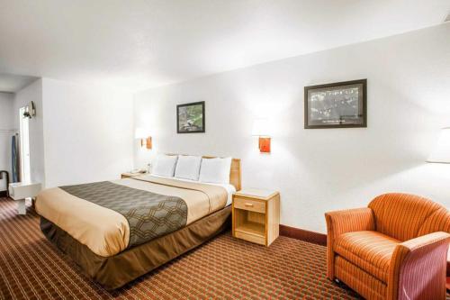 a hotel room with a bed and a chair at Econo Lodge Truman Inn in Sedalia