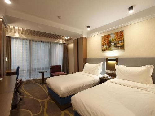 a hotel room with two beds and a chair at Dalian Bohai Pearl Hotel in Dalian