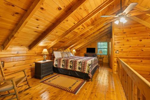 a bedroom in a log cabin with a bed and a ceiling fan at Cherry Lake Hideaway in Blue Ridge