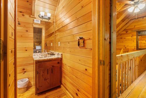 a log cabin bathroom with a sink and a mirror at Cherry Lake Hideaway in Blue Ridge