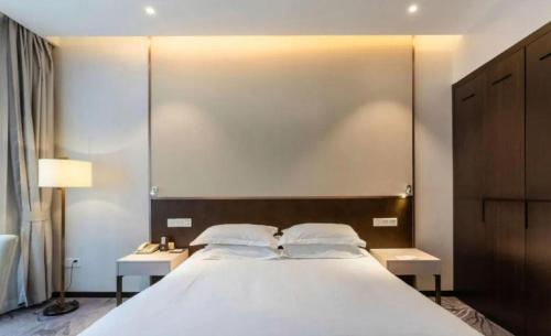 a bedroom with a large white bed with two tables at International Conference Hotel Nanjing in Nanjing