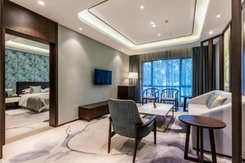 a hotel room with a bed and a table and chairs at International Conference Hotel Nanjing in Nanjing