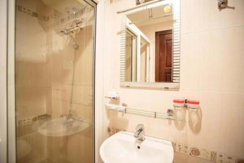 Binh Hung Hotel في مدينة هوشي منه: حمام مع حوض ودش ومرآة