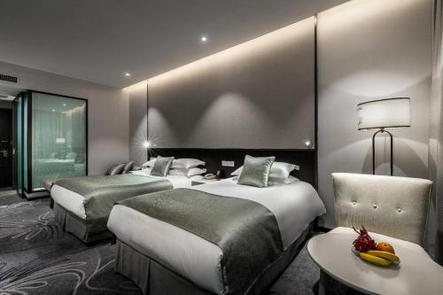 a hotel room with two beds and a table at International Conference Hotel Nanjing in Nanjing