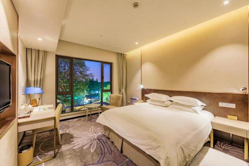 a bedroom with a large bed and a large window at International Conference Hotel Nanjing in Nanjing