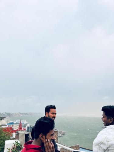 a group of men standing on top of a building at River view paying guest house in Varanasi
