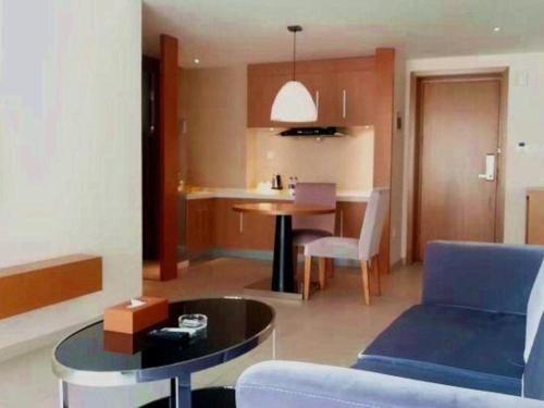 a living room with a blue couch and a table at Da Peng Zhongzhou Hotel in Haikou