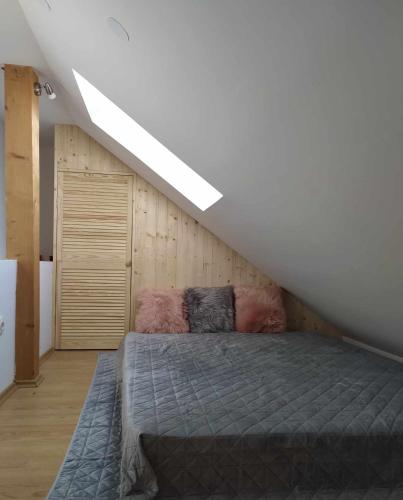 a bedroom with a bed and a sloped ceiling at Karmelita vendégház in Sopron