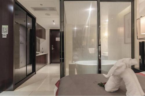 a white stuffed animal sitting on a bed in a bathroom at Da Peng Zhongzhou Hotel in Haikou