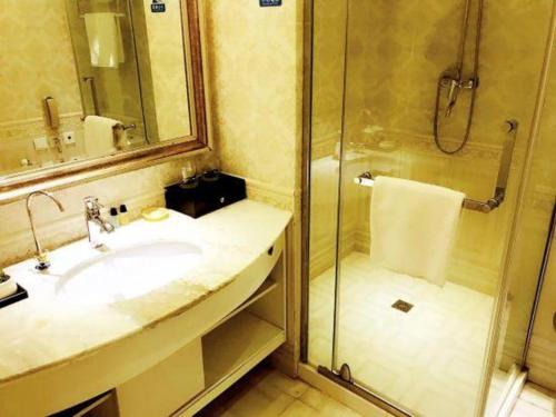 a bathroom with a sink and a shower at New century Manju Select Hotel Hongqiao Hub National Exhibition Center in Shanghai