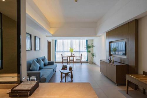 a living room with a blue couch and a table at Da Peng Zhongzhou Hotel in Haikou