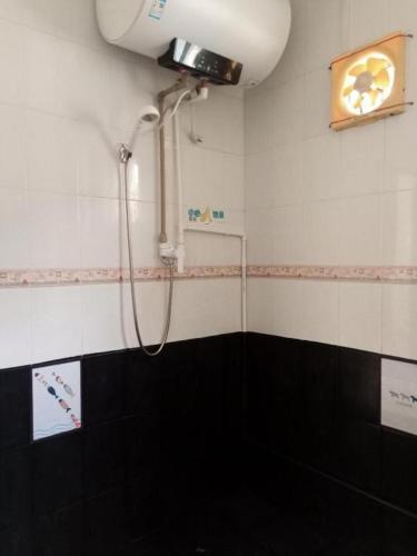 a bathroom with a shower with a camera on the wall at Beihai forget dust International Youth Hostel in Beihai