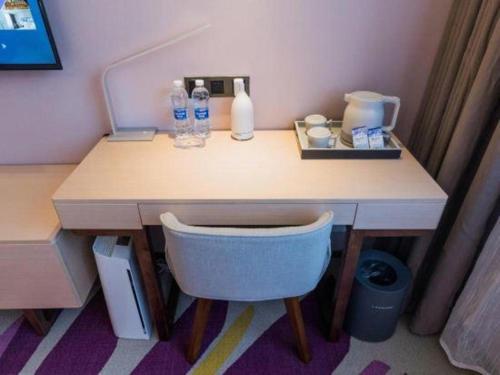 a desk with a chair and water bottles on it at Lavande Hotels·Yichang Wanda Plaza in Yichang