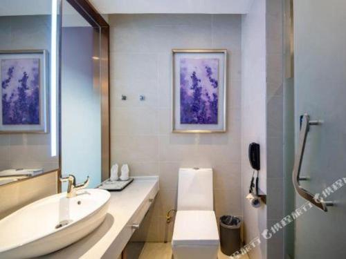 a bathroom with a tub and a sink and a mirror at Lavande Hotels·Yichang Wanda Plaza in Yichang