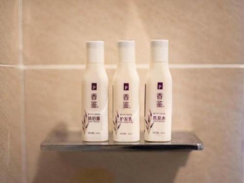 a group of four bottles on a shelf in a bathroom at Lavande Hotels·Yichang Wanda Plaza in Yichang