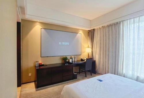 a hotel room with a bed and a projection screen at Hefei Parkview Hotel in Hefei