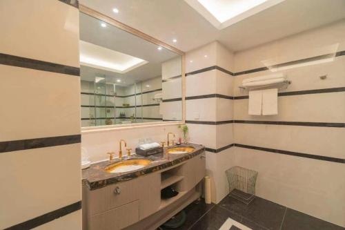 a bathroom with two sinks and a large mirror at Hefei Parkview Hotel in Hefei