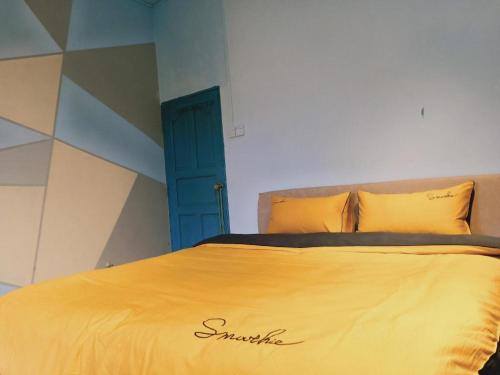 a bedroom with a yellow bed with a blue door at Beihai forget dust International Youth Hostel in Beihai