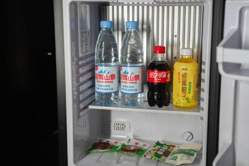 a refrigerator filled with bottles of water and drinks at Hefei Parkview Hotel in Hefei