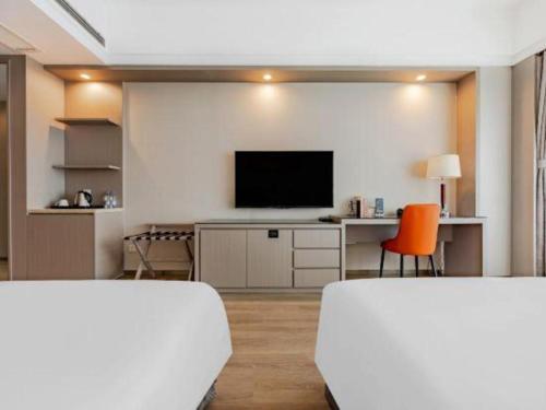 a living room with a tv and a desk with a computer at Hefei Parkview Hotel in Hefei