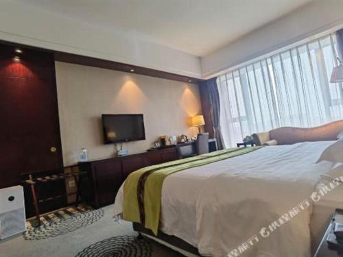 a hotel room with a bed and a flat screen tv at Hefei Parkview Hotel in Hefei