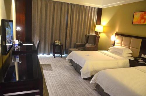 a hotel room with two beds and a chair at Hefei Parkview Hotel in Hefei