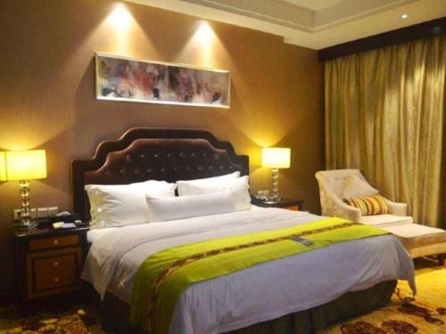 a hotel room with a large bed and a chair at Hefei Parkview Hotel in Hefei